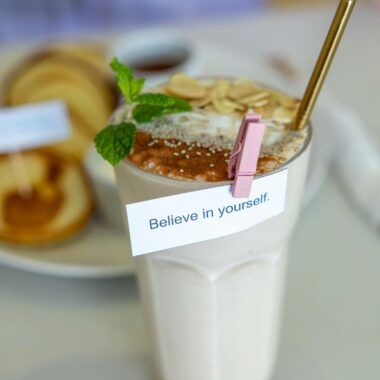A delicious smoothie topped with almonds, mint, and an inspiring note for motivation.